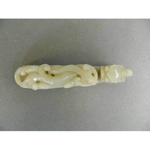 147 - A Chinese celadon jade belt hook with carved dragon decoration, 4½