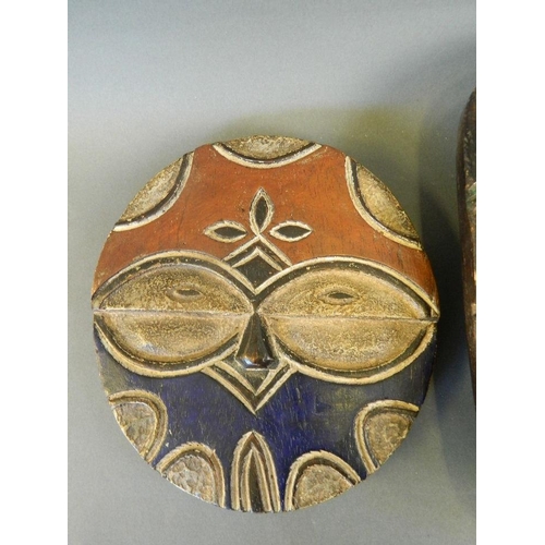 150 - An African circular wood mask with oval eyes and painted highlights, Democratic Republic of Congo Te... 