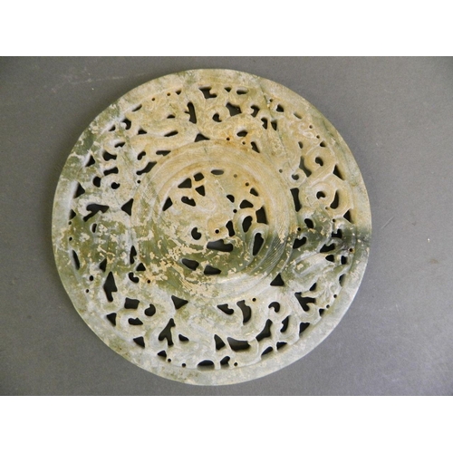 150C - A large Chinese archaic mottled green jade pi-disc with carved and pierced dragon decoration, 6½