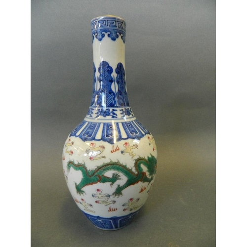 177 - A Chinese blue and white porcelain bottle vase decorated with green and red dragons amongst yellow c... 