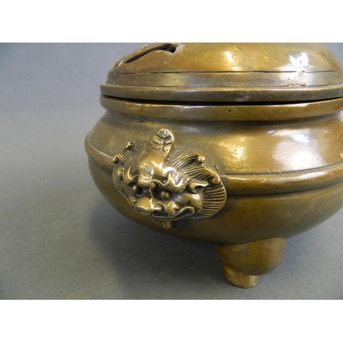 209 - A Chinese bronze censer and lid with twin dragon mask handles and kylin decoration, on tripod suppor... 