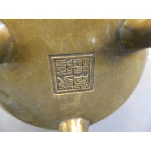 209 - A Chinese bronze censer and lid with twin dragon mask handles and kylin decoration, on tripod suppor... 