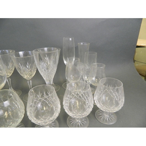 21 - An assorted collection of drinking glasses to include brandy balloons, flutes, goblets etc