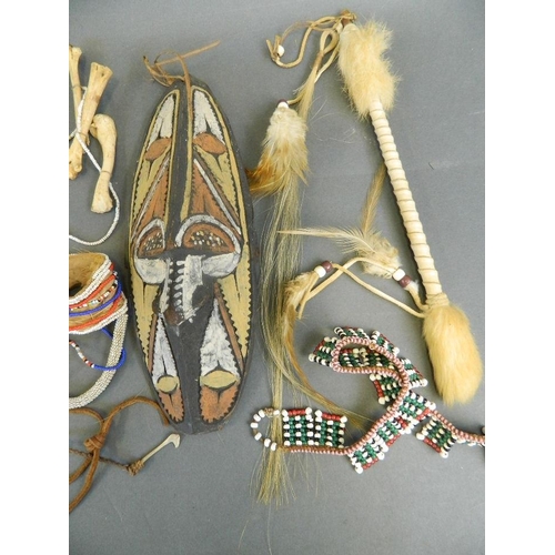 211 - A collection of ethnic items including a painted mask, bone and bead necklaces etc