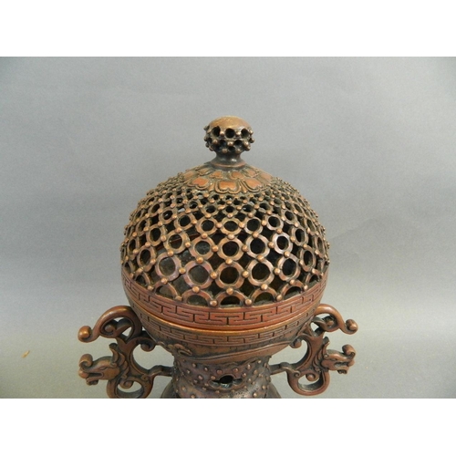 3 - A Chinese twin handled coppered metal incense burner with a pierced lid and stylised dragon decorati... 