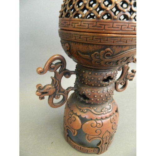 3 - A Chinese twin handled coppered metal incense burner with a pierced lid and stylised dragon decorati... 