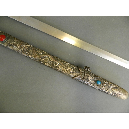 32 - A Chinese Jian sword with silvered metal scabbard and hilt, the blade with repoussé dragon decoratio... 