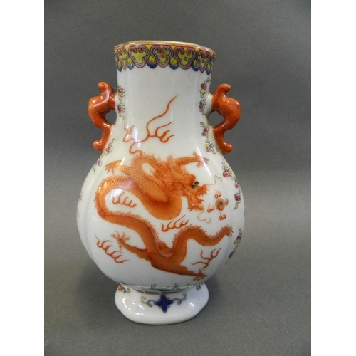 41 - A Chinese twin handled porcelain vase decorated with dragons chasing the flaming pearl in bright ena... 