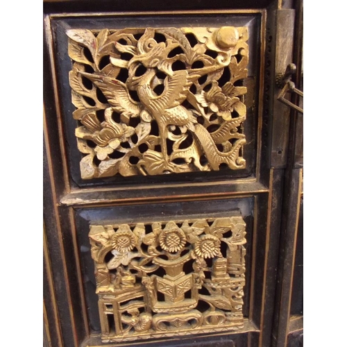 475 - A Chinese black lacquer and gilt table top shrine cabinet, the doors decorated with pierced and carv... 