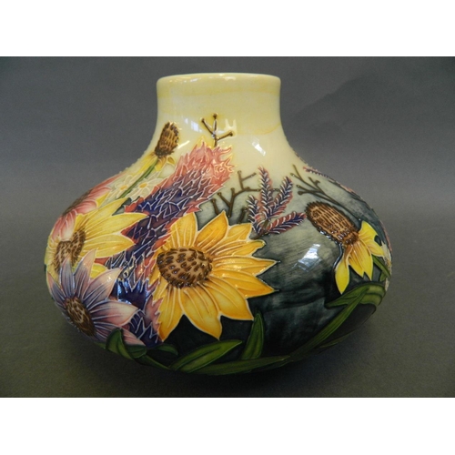 64 - A Continental studio pottery vase of squat form decorated with flowers in the style of Moorcroft, 4½... 