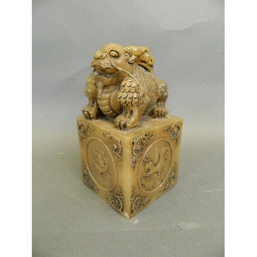 69 - A Chinese soapstone seal with carved kylin knop and decorative panels depicting mythical beasts, 5½