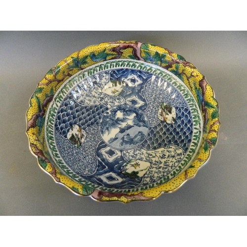 86 - A Japanese porcelain bowl with blue and white interior decorated with a landscape and a brightly col... 