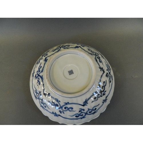 86 - A Japanese porcelain bowl with blue and white interior decorated with a landscape and a brightly col... 