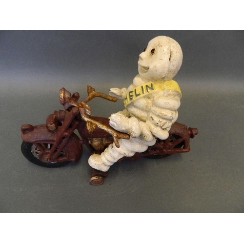 12 - A cast iron advertising figure of the Michelin Man riding a motorcycle, 9