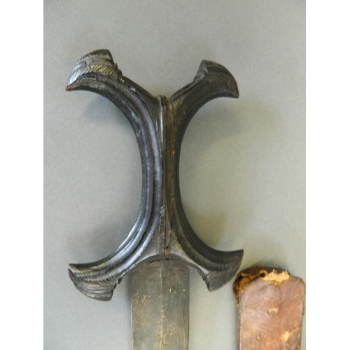 21 - An Eastern curved dagger with carved crucifix handle and leather sheath, 13½