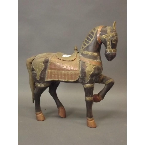 47 - An Eastern carved wood figure of a horse with brass and copper saddle and mounts, together with an O... 