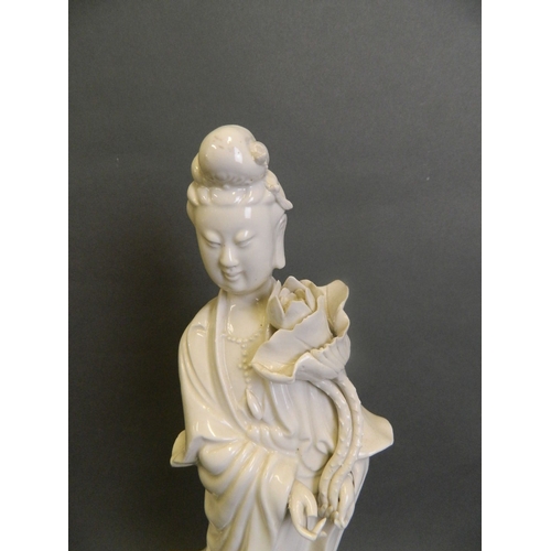 50K - A Chinese Blanc de Chine porcelain figure of Quan Yin standing upon a lotus flower, 14½