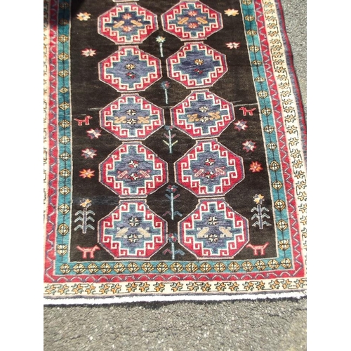 782 - A black ground Persian tribal carpet with Bokhara design, 88