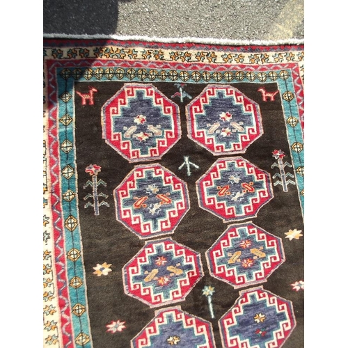 782 - A black ground Persian tribal carpet with Bokhara design, 88