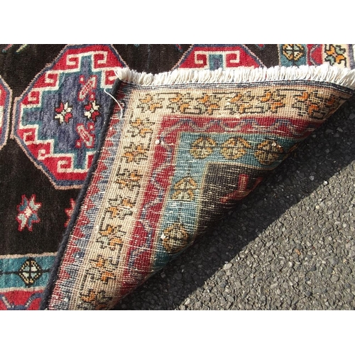 782 - A black ground Persian tribal carpet with Bokhara design, 88