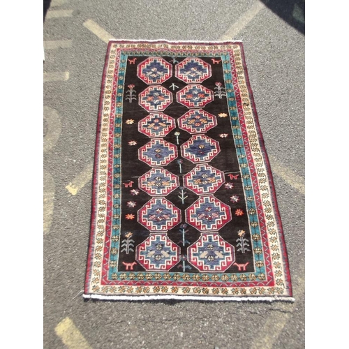 782 - A black ground Persian tribal carpet with Bokhara design, 88