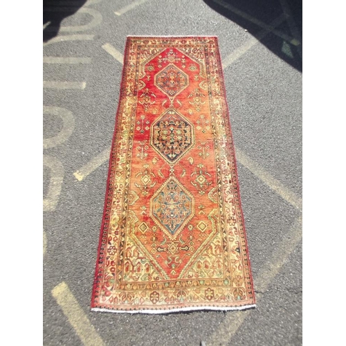 783 - An old red ground Persian Sarouk runner, signed and dated, 42