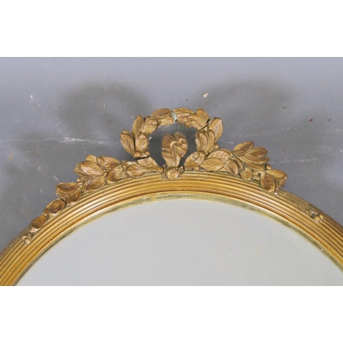 786 - An Edwardian gilt oval shaped wall mirror with reeded frame and floral decoration (AF losses)