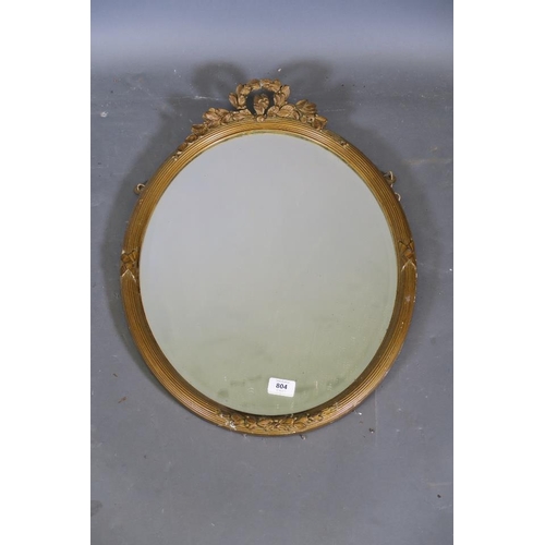 786 - An Edwardian gilt oval shaped wall mirror with reeded frame and floral decoration (AF losses)