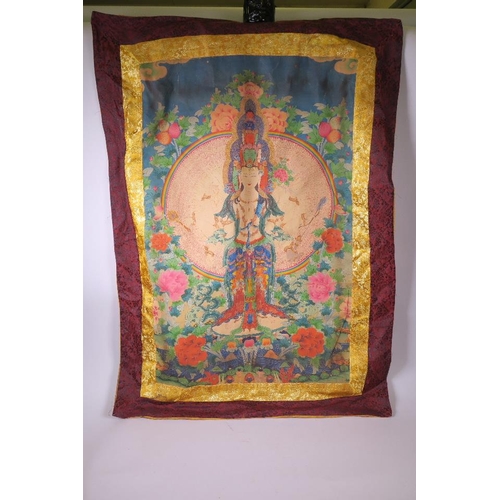 16 - A Tibetan printed silk thangka depicting Buddha surrounded by lotus flowers and peaches, 31