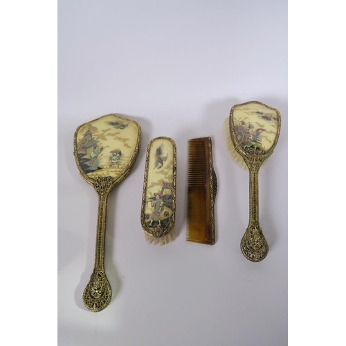 36 - A chinoiserie four piece dressing table set comprising hand mirror, two brushes and a comb, with gil... 