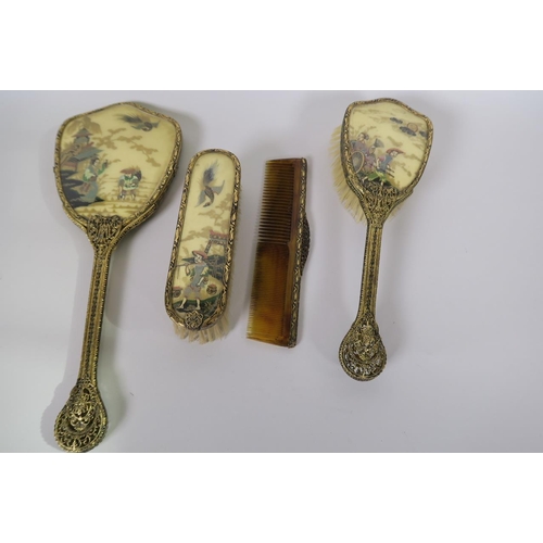 36 - A chinoiserie four piece dressing table set comprising hand mirror, two brushes and a comb, with gil... 