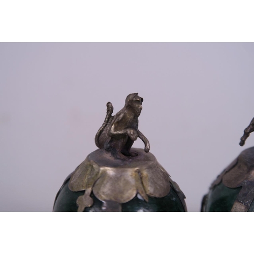 50H - A pair of Chinese white metal mounted green hardstone paperweights with goat and monkey finials, 2