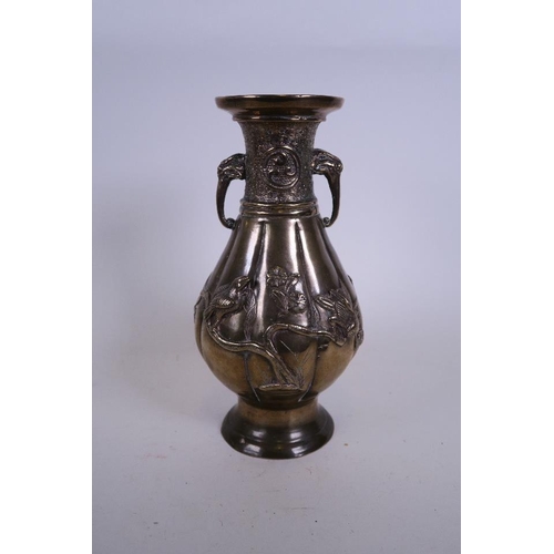 50M - An Oriental bronze ribbed vase with twin elephant mask handles and applied relief decoration of bird... 