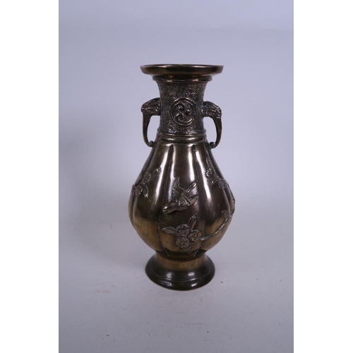 50M - An Oriental bronze ribbed vase with twin elephant mask handles and applied relief decoration of bird... 