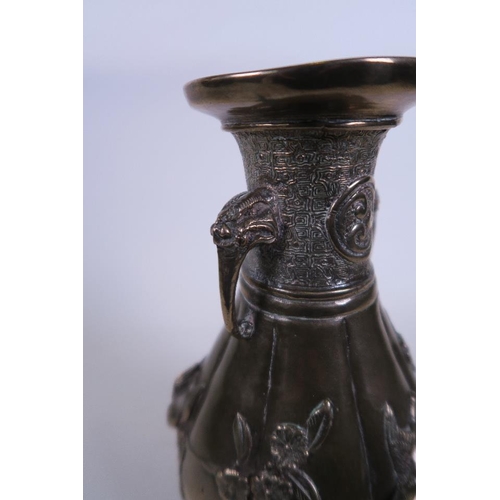 50M - An Oriental bronze ribbed vase with twin elephant mask handles and applied relief decoration of bird... 