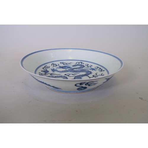 19 - A Chinese blue and white porcelain dish decorated with a dragon chasing the flaming pearl, 6 charact... 