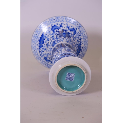 27 - A Chinese blue and white porcelain Gu shaped vase with lotus flower decoration and gilt highlights, ... 