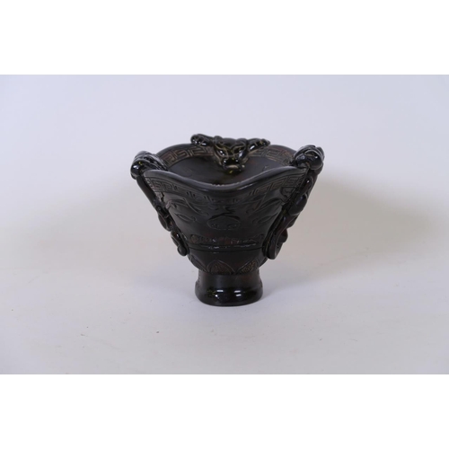 49 - A Chinese carved horn libation cup decorated with climbing kylin, carved mark to base, 5½