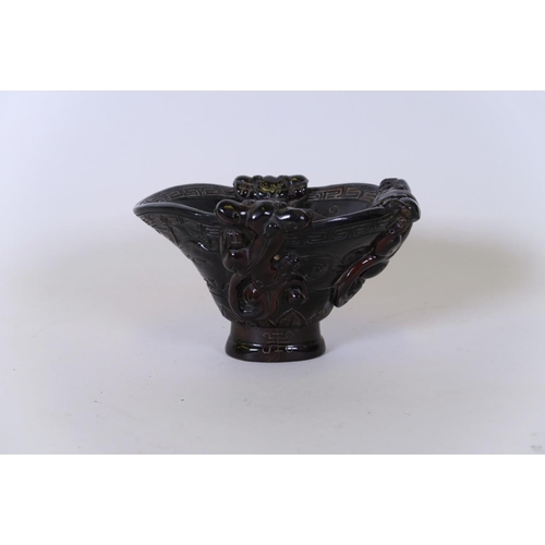 49 - A Chinese carved horn libation cup decorated with climbing kylin, carved mark to base, 5½