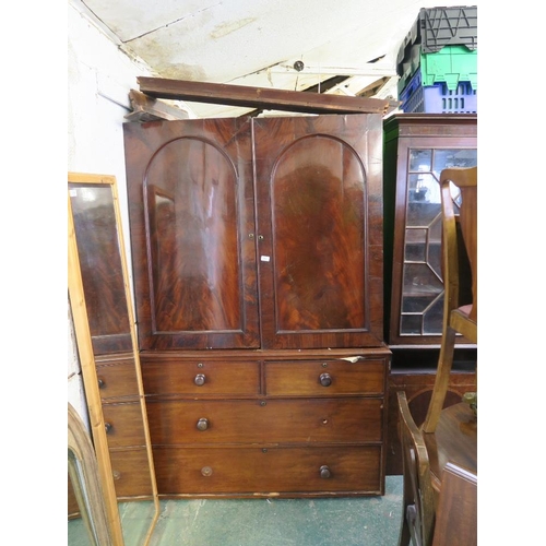 932 - A C19th mahogany press cupboard, the upper section fitted with slides over a lower section of two ov... 