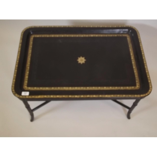 867 - A gilt tooled leather topped tray by Maitland Smith on an ebonised stand with ring turned supports, ... 