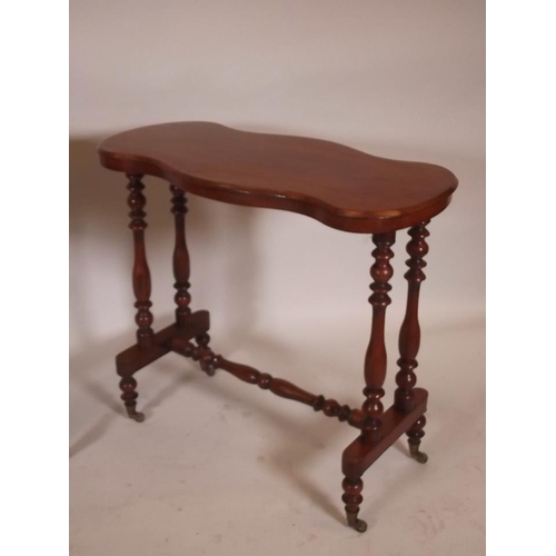 882 - A Victorian walnut stretcher table with serpentine form top, raised on turned end supports, and a ma... 