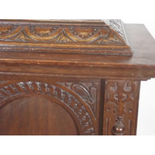 863 - A C19th French oak two door cabinet with carved and fluted decoration, raised on bun feet, 33