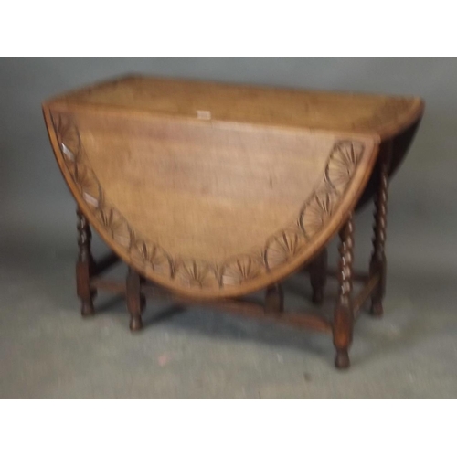 889 - An oak drop leaf gateleg table on barleytwist supports, the top carved with Art Deco fan patterns, 4... 