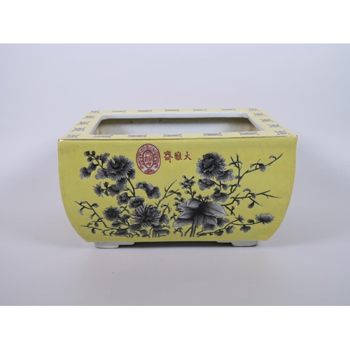 103 - A Chinese yellow ground porcelain planter with black and white floral decoration, character marks to... 