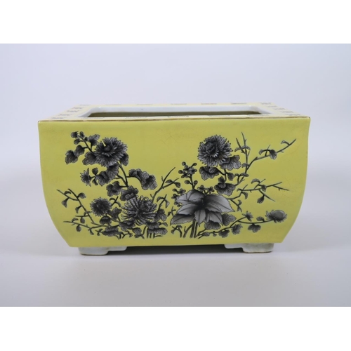 103 - A Chinese yellow ground porcelain planter with black and white floral decoration, character marks to... 