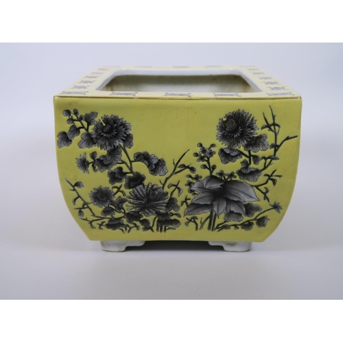 103 - A Chinese yellow ground porcelain planter with black and white floral decoration, character marks to... 