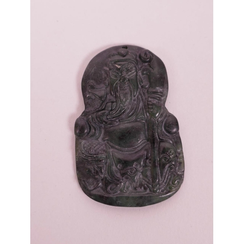 107 - A Chinese mottled spinach hardstone/jade pendant with carved decoration of a warrior deity, 2