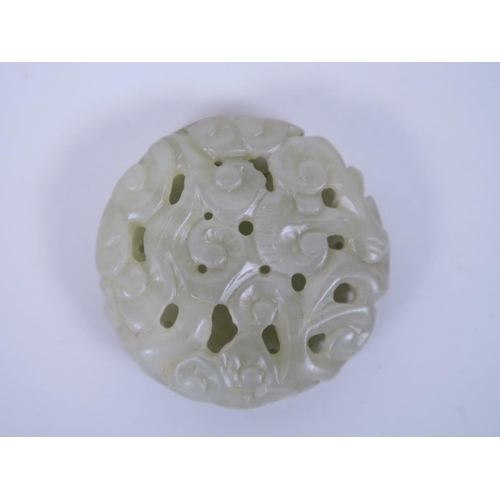 11 - A Chinese celadon jade pendant with carved and pierced scrolling decoration, 2