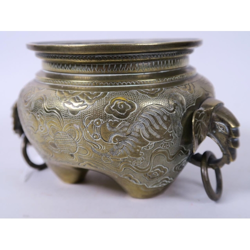 19 - A Chinese bronze censer with elephant's head ring handles and engraved decoration, raised on three f... 